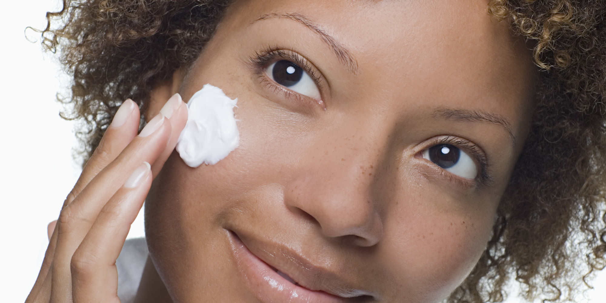 Attractive woman applying moisturizer